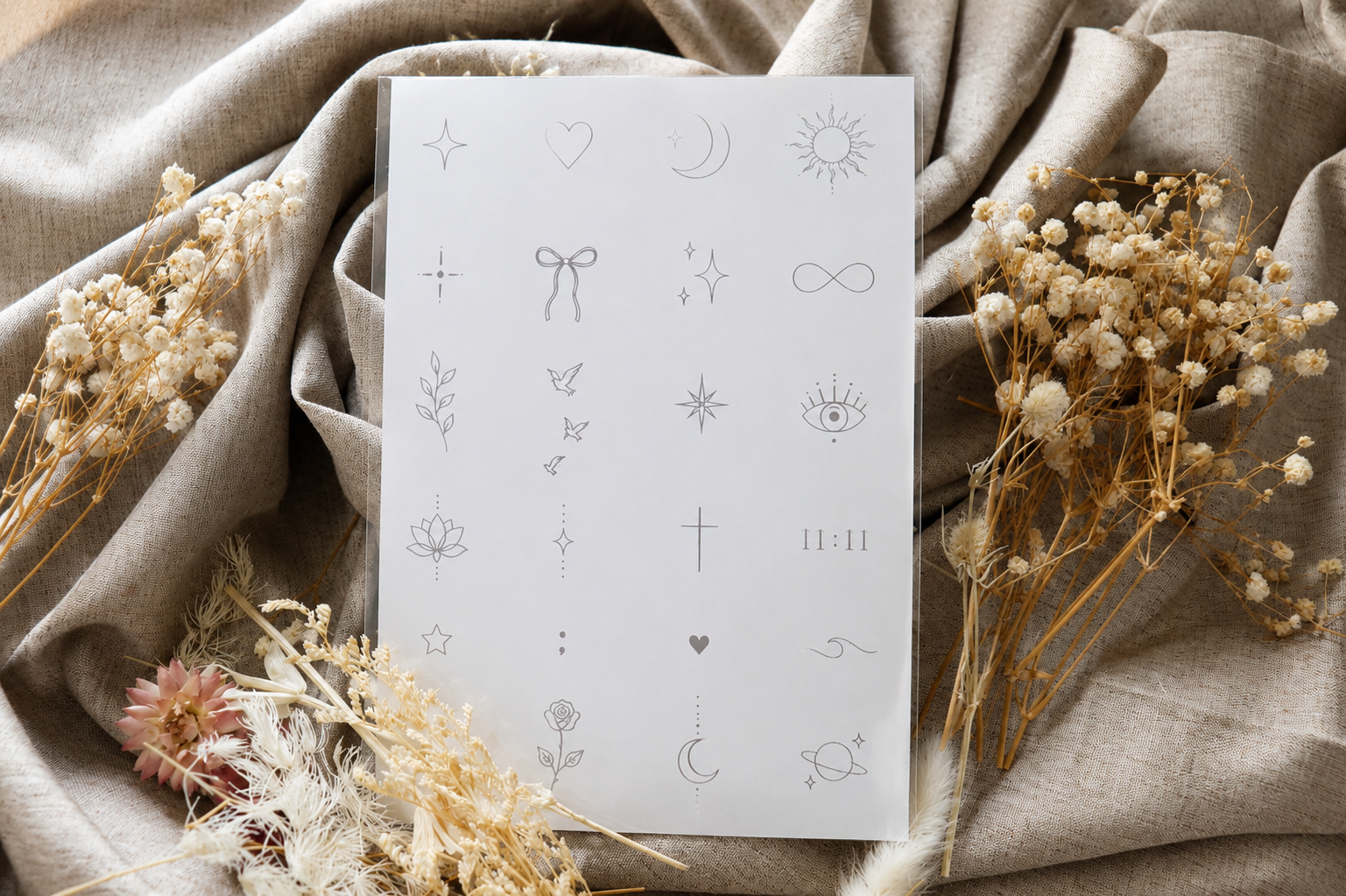 Planche verso de tatouages temporaires minimalistes SKNLY – Collection Signature avec étoile, cœur, lune, soleil, nœud, infini, œil protecteur et oiseaux en envol