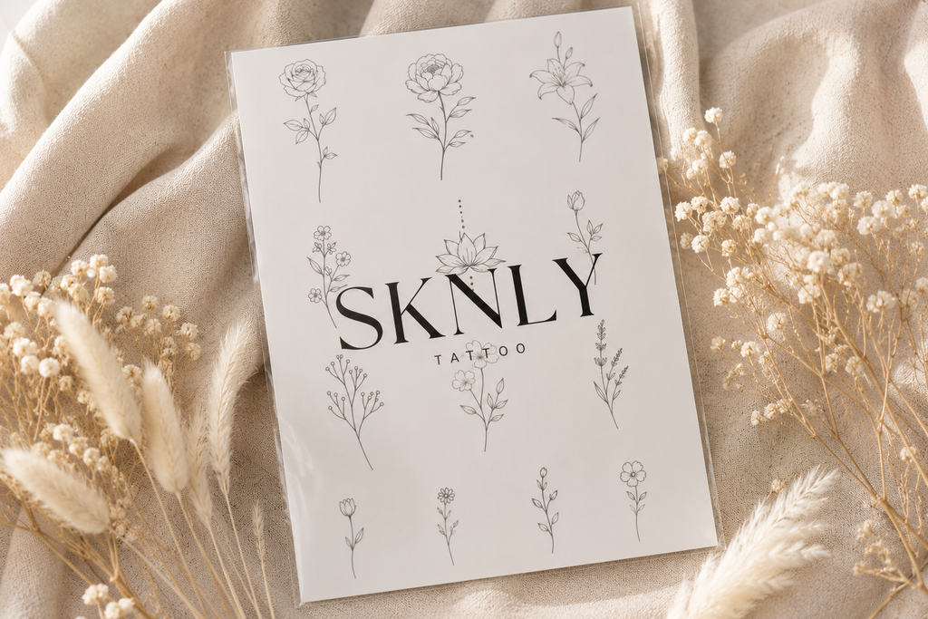 Planche de tatouages éphémères floraux SKNLY avec motifs de fleurs minimalistes sur fond beige