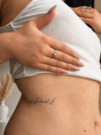 Tatouage éphémère phrase arabe SKNLY porté sur le ventre avec rendu réaliste
